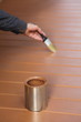 Painter in action, painting floor with brown wood stain