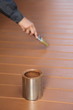 Painter in action, painting floor with brown wood stain