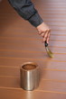 Painter in action, painting floor with brown wood stain