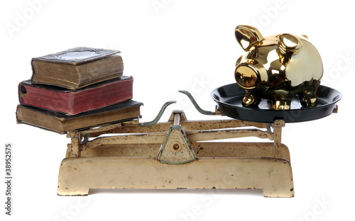 Photo: scale with books and golden piggy bank scale with books and golden piggy bank