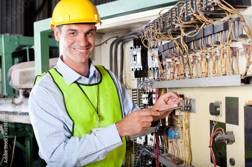 Photo: technician repairing industrial machine control box technician repairing industrial machine control box