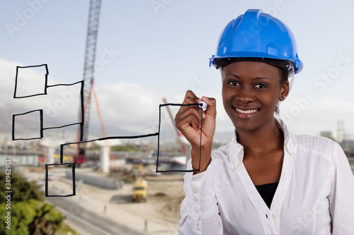 Photo: Copyspace image of woman with hard-hat making a drawing.. Copyspace image of woman with hard-hat making a drawing..