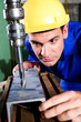 factory worker using industrial drilling machine