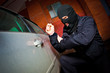 robber and the thief in a mask hijacks the car