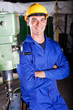 industrial machinist standing next to machine tool