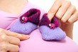 schwangere frau mit babyschuhen