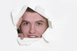 Photo: young man peeping through hole in paper young man peeping through hole in paper