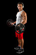 Young man lifting weight with headphones, on black