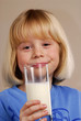 Niña bebiendo un vaso de leche.
