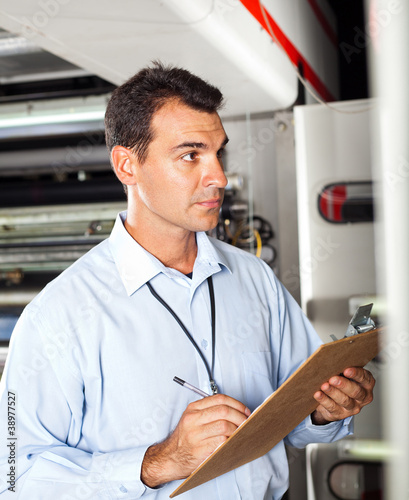 Photo: industrial technician taking machine readings industrial technician taking machine readings