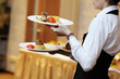 Waitress is carrying three plates with meat dish Waitress is carrying three plates with meat dish