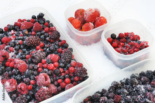Photo: Plastic containers of frozen mixed berries in snow Plastic containers of frozen mixed berries in snow