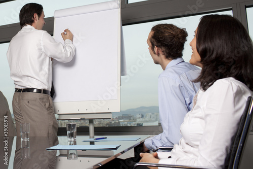 Photo: Group of office workers in a boardroom presentation Group of office workers in a boardroom presentation