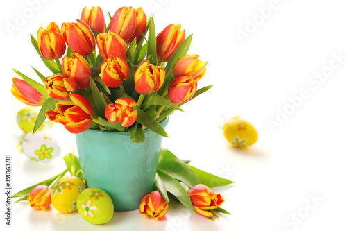 Photo: Beautiful bouquet of tulips in vase with Easter eggs on white ba Beautiful bouquet of tulips in vase with Easter eggs on white ba