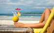 Holding a cocktail on a tropical beach