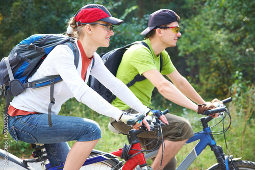Photo: Couple riding bicycle in park Couple riding bicycle in park