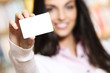 Photo: smiling young female showing a business card - copy space. smiling young female showing a business card - copy space.