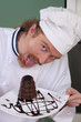 Photo: Funny young chef eating a piece of cake Funny young chef eating a piece of cake