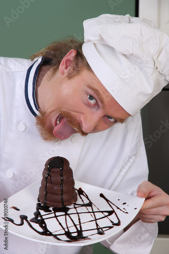 Photo: Funny young chef eating a piece of cake Funny young chef eating a piece of cake