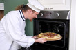 Photo: Young chef prepared italian pizza in kitchen Young chef prepared italian pizza in kitchen
