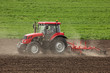 Foto: Small scale farming with tractor and plow in field Small scale farming with tractor and plow in field