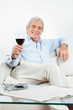 Senior prostet mit Glas Rotwein zu Senior prostet mit Glas Rotwein zu