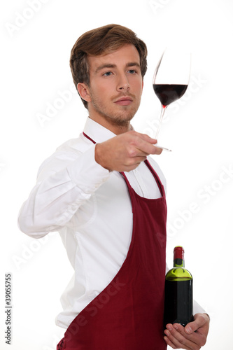 Photo: Sommelier holding up a glass of wine Sommelier holding up a glass of wine