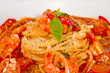 A plate of linguini with sauteed shrimp, tomato, chili  and oliv