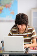 Teenager using his laptop at school