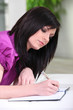 Young woman writing on a notebook