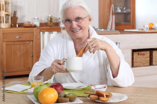 Photo: A mature woman having breakfast. A mature woman having breakfast.