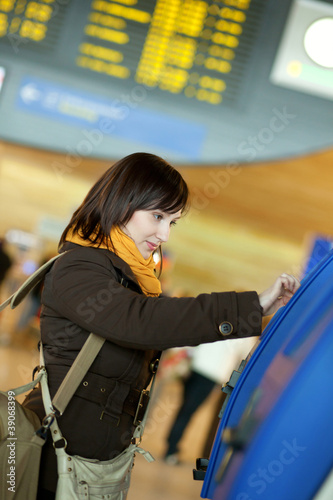Photo: Girl doing self-checkin in the airport Girl doing self-checkin in the airport