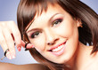Attractive smiling girl with scissors, cutting her hair