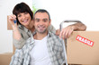 Couple moving into new home with doorkeys and boxes