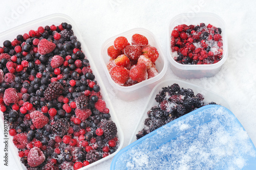 Photo: Plastic containers of frozen mixed berries in snow Plastic containers of frozen mixed berries in snow