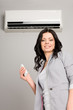 Photo: girl with a remote control air conditioner girl with a remote control air conditioner
