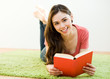 Photo: Young woman reading the book at home Young woman reading the book at home
