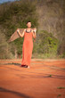 Beautiful girl dressed  terracotta dress with a scarf in her han