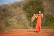 Beautiful girl dressed  terracotta dress with a scarf in her han