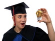 Beautiful girl in the graduation cap and glass bulb with coins Beautiful girl in the graduation cap and glass bulb with coins