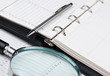 pen, magnifying glass and diary