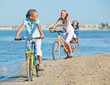 Cute girl with her mother and brother ride bikes