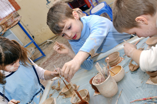 Foto: group of hildren shaping clay in pottery studio group of hildren shaping clay in pottery studio