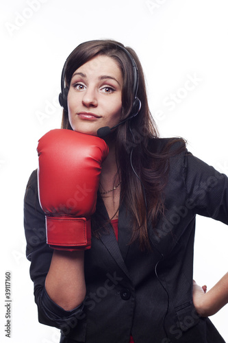 Photo: Businesswoman hitting herself with boxing gloves Businesswoman hitting herself with boxing gloves