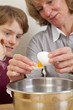 Mutter und Sohn beim Backen - Eier werden getrennt
