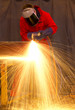 Welder in red creates huge orange sparks Welder in red creates huge orange sparks