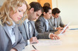 Young business people signing application form