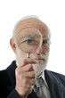 Photo: an old man sees through in magnifying lens an old man sees through in magnifying lens