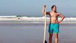 Man with surfing board walking on the surfers beach, slow motion