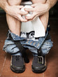 Man sitting on toilet bowl